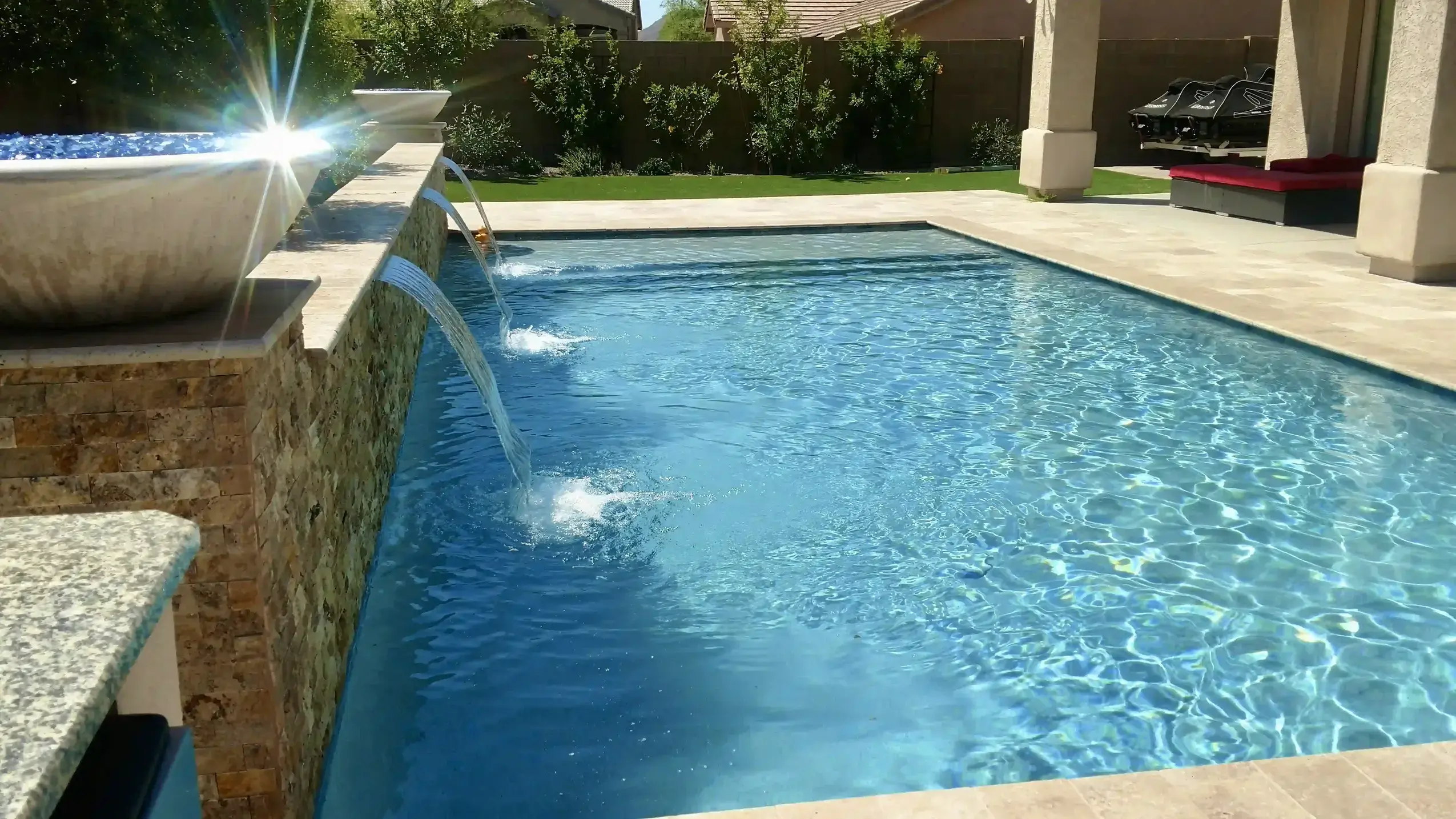 Clear blue backyard pool with water features
