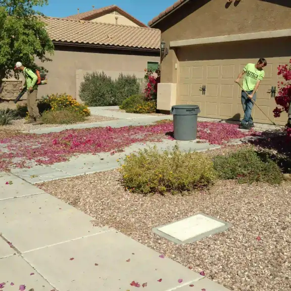 Crew cleaning up a front yard with gravel and shrubs