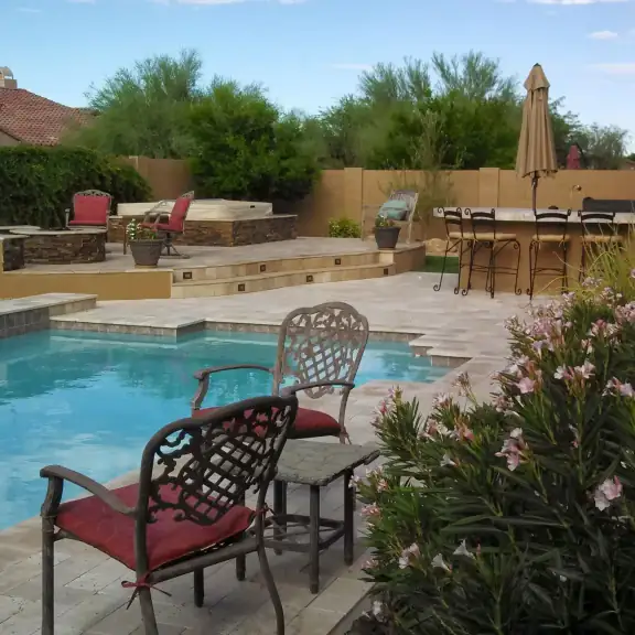 Pool with patio chairs and flowering shrubs