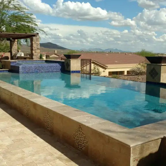 Infinity edge pool with pergola and desert view