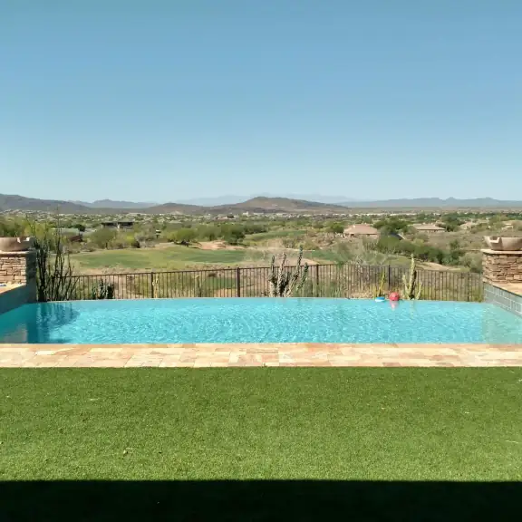 Pool with turf and wide desert mountain view