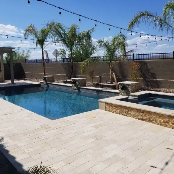 Rectangular pool and spa with palms and string lights