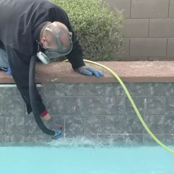 Technician cleaning pool tile line (square)